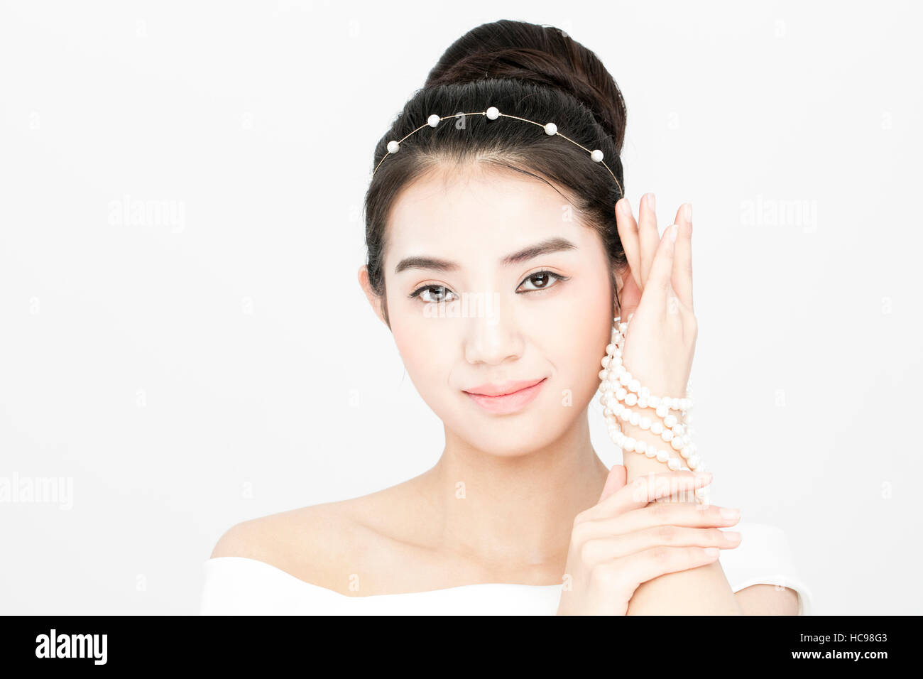 Portrait of young smiling bride holding pearl necklace Banque D'Images