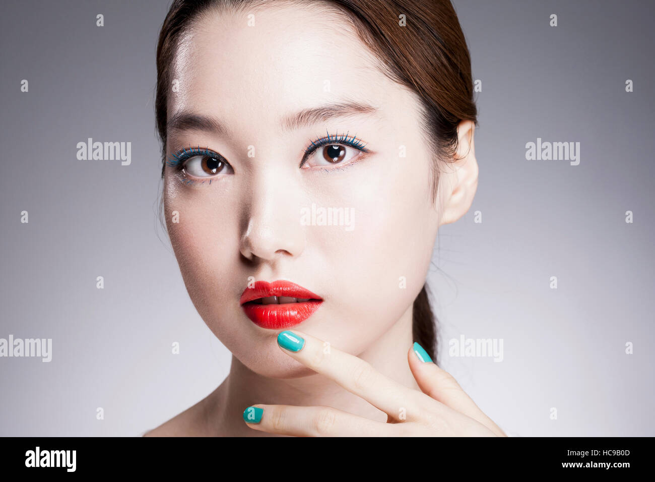 Portrait de jeune femme coréenne avec des lèvres rouge et bleu de vos ongles Banque D'Images