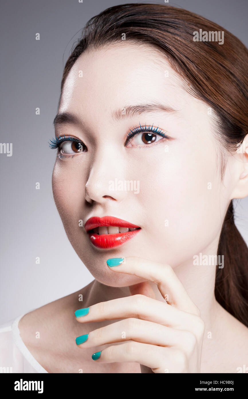 Portrait de jeune femme coréenne avec des lèvres rouge et bleu de vos ongles Banque D'Images