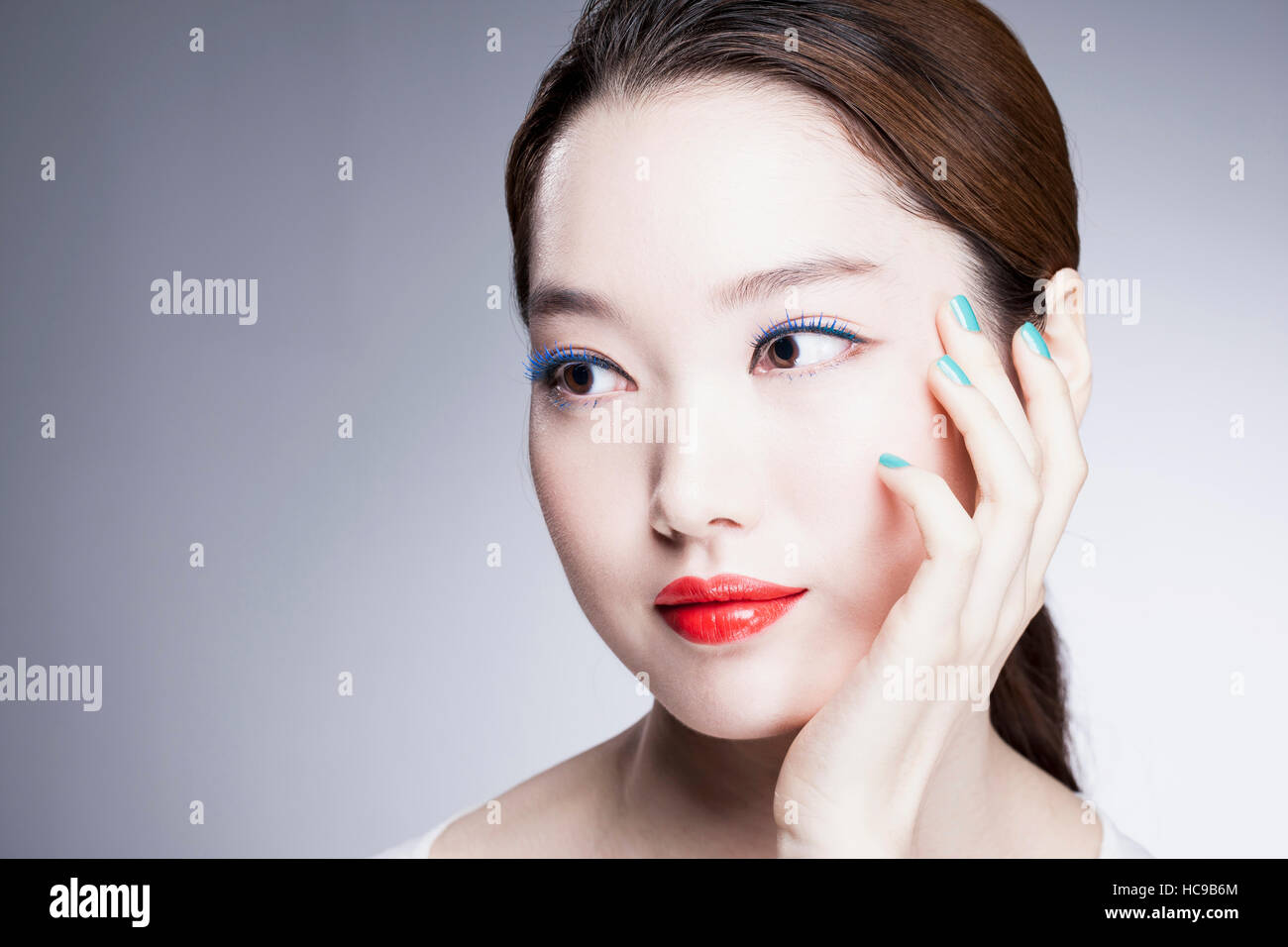 Portrait de jeune femme coréenne avec des lèvres rouge et bleu nails Banque D'Images