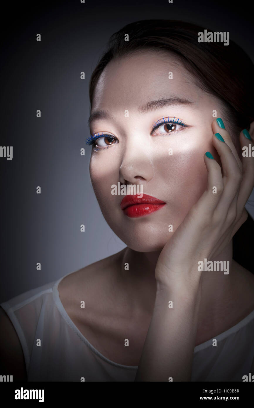 Portrait de jeune femme coréenne avec des lèvres rouge et bleu nails Banque D'Images