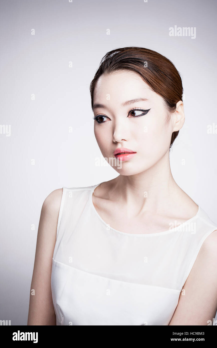 Portrait de jeune femme coréenne en noir eye liner et des vêtements blancs Banque D'Images