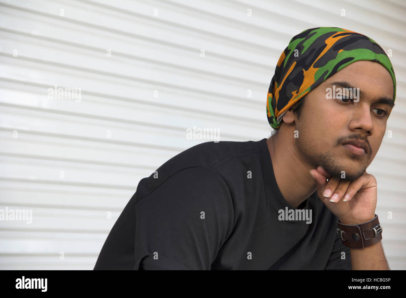 Close-up of young indian boy with hand on chin pense Banque D'Images