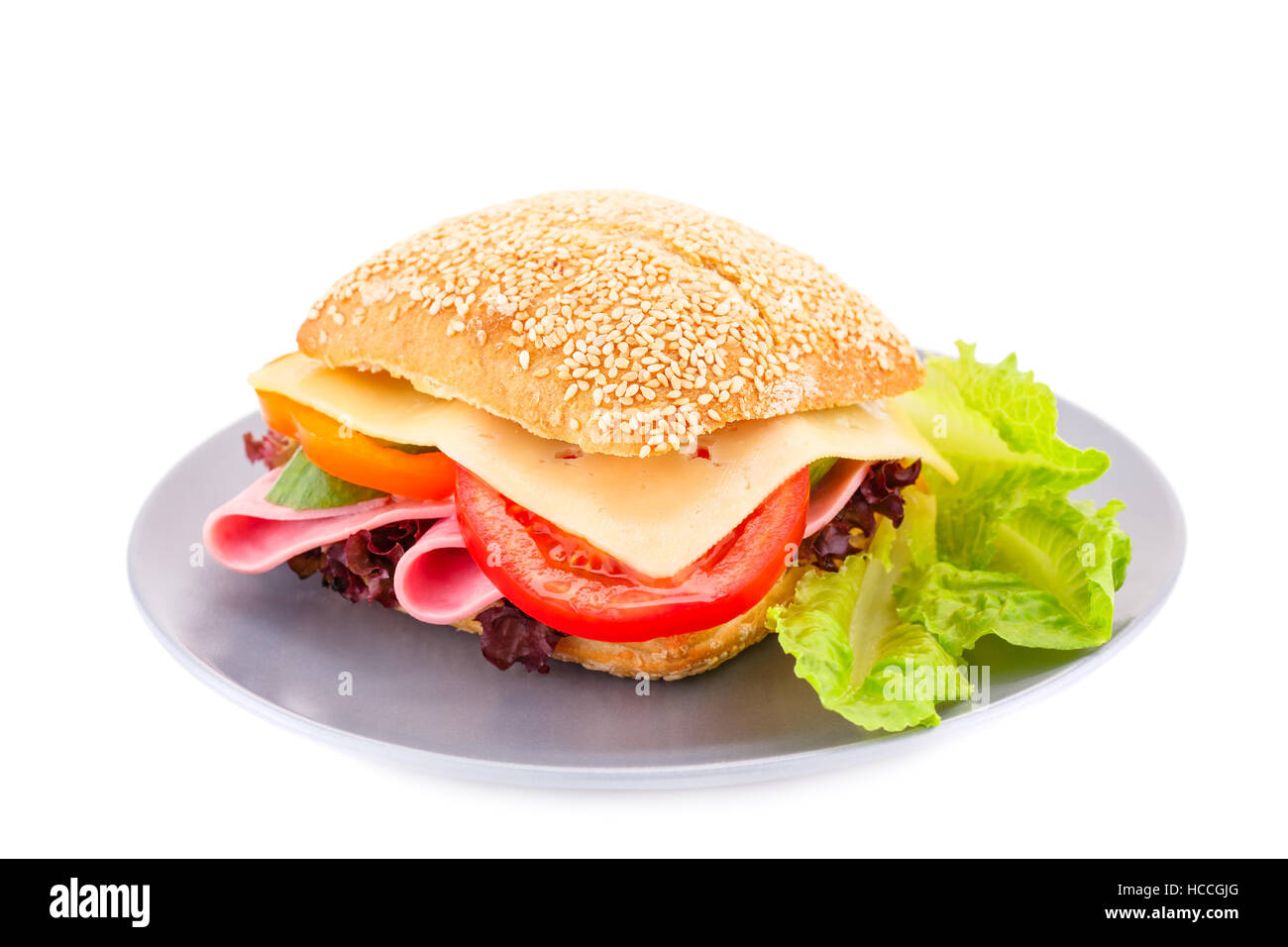 Sandwich avec des légumes frais, jambon et fromage sur la plaque. Banque D'Images