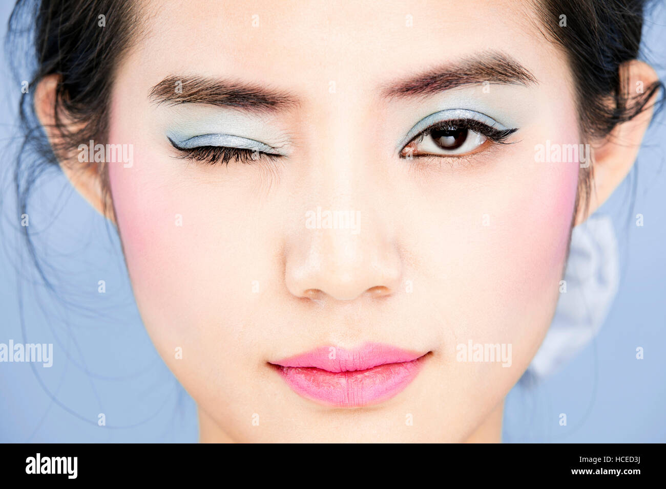 Portrait de jeune femme aux lèvres roses et des yeux bleus avec un clin Banque D'Images
