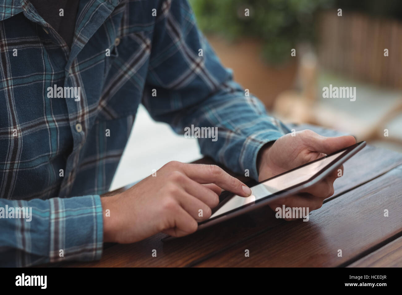 L'homme assis à un bureau et using digital tablet Banque D'Images