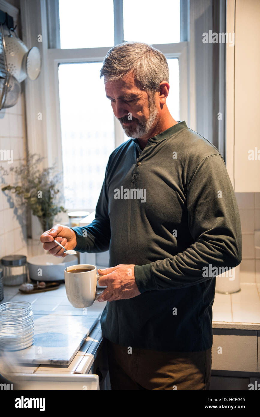 L'homme de préparer un café noir dans la cuisine Banque D'Images