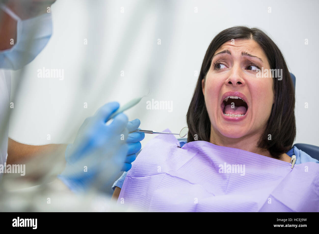 Female patient effrayé pendant un examen dentaire Banque D'Images