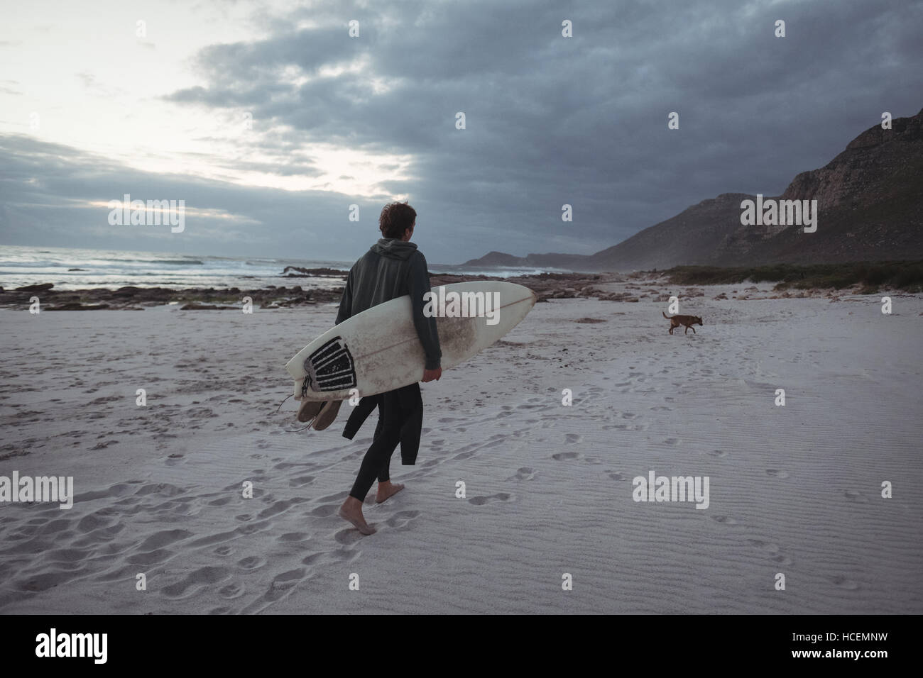 Man carrying surfboard on beach Banque D'Images