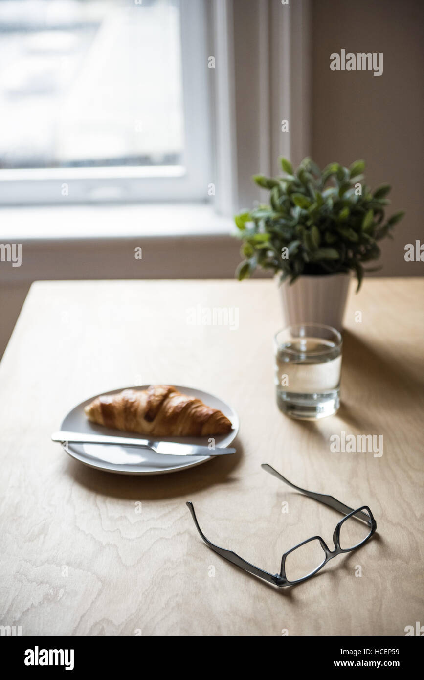 Le petit-déjeuner avec plante en pot et le spectacle sur la table Banque D'Images