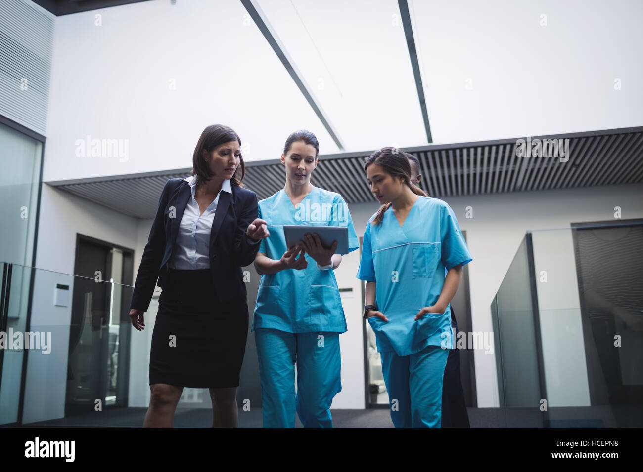Médecin et infirmières discuter sur tablette numérique Banque D'Images
