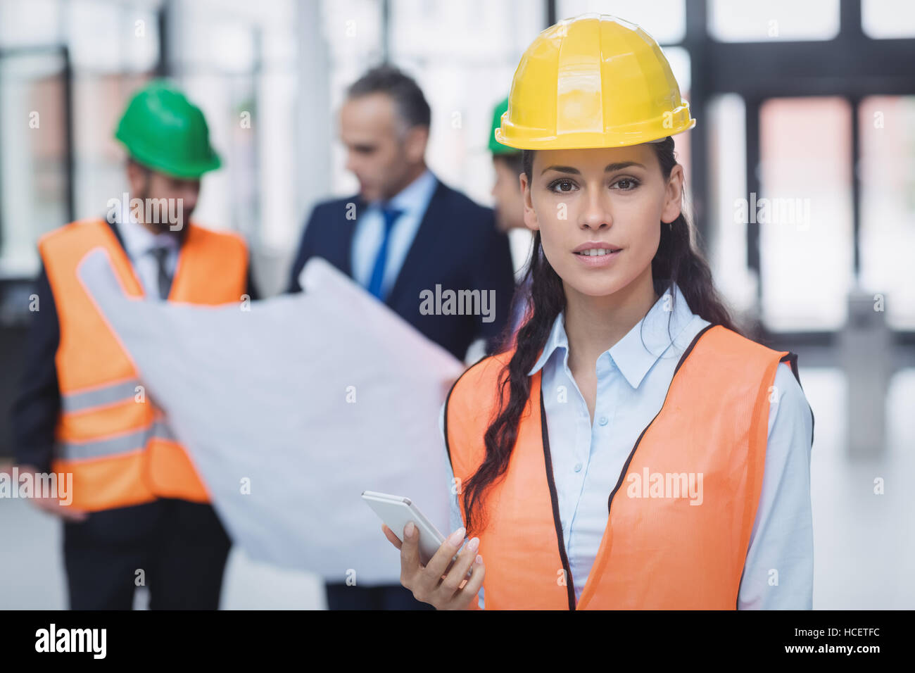 Female architect holding mobile phone Banque D'Images