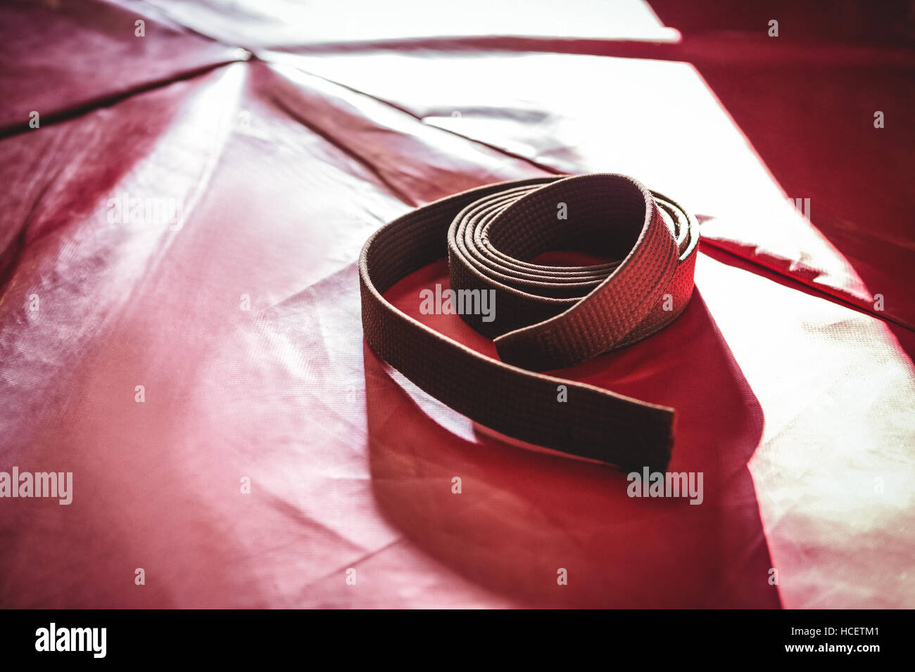 Ceinture marron de karaté sur surface rouge Banque D'Images