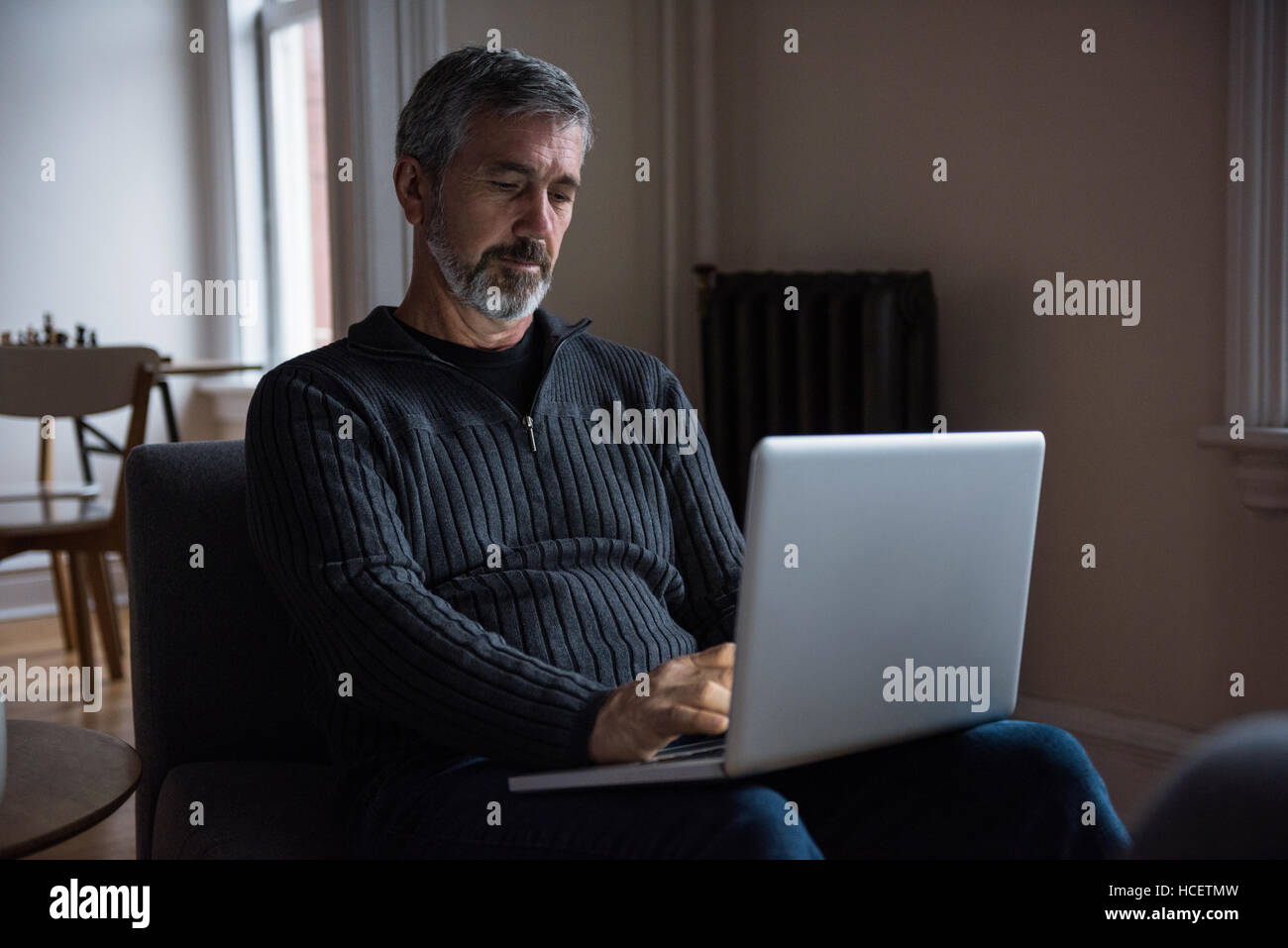 Man sitting on sofa and using laptop Banque D'Images