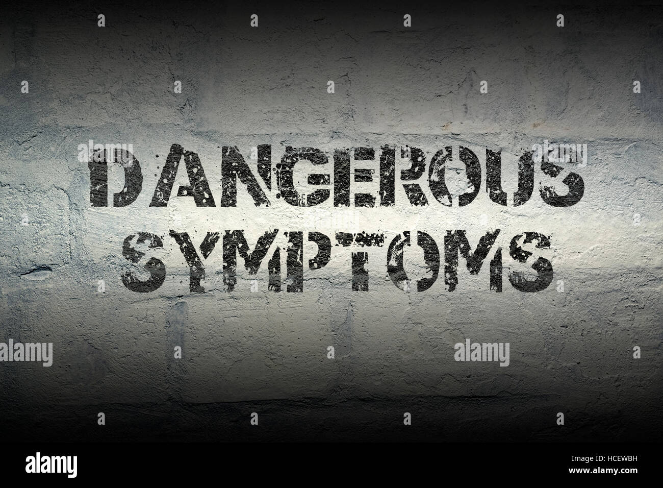 Symptômes dangereux d'impression au pochoir sur le mur de brique blanc grunge Banque D'Images