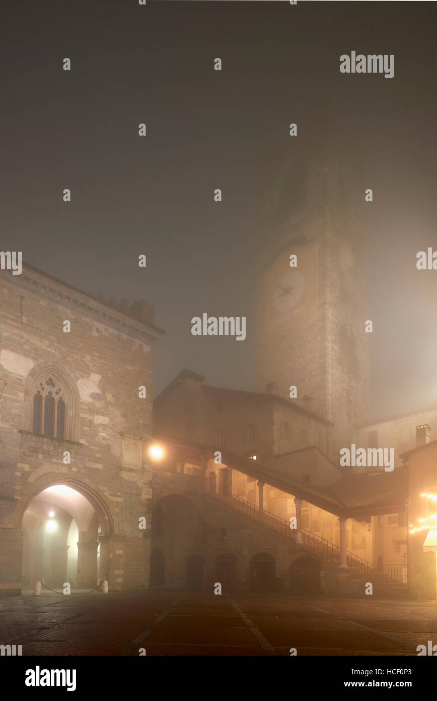 Bergame, Italie. La Piazza Vecchia dans le brouillard. La Torre Civica, et le Palazzo della Ragione Banque D'Images