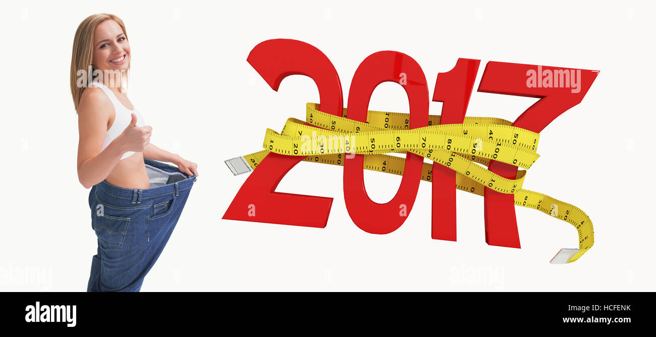 Image composite de portrait de femme portant un pantalon vieux après avoir perdu du poids et gesturing Thumbs up Banque D'Images