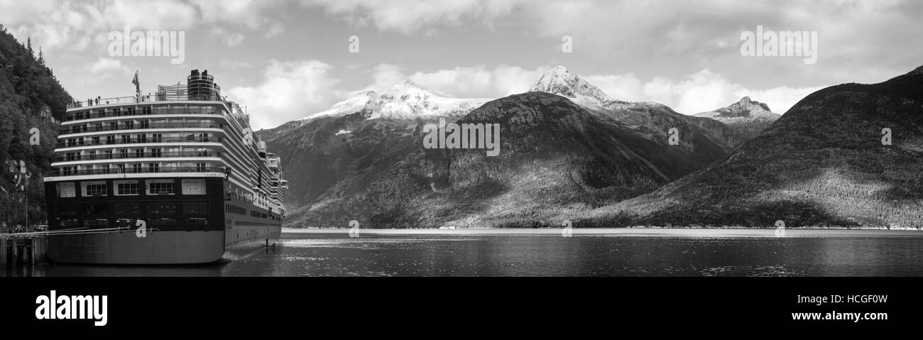 La vue panoramique d'une chaîne de montagnes et un bateau de croisière amarré dans la ville de Skagway (Alaska). Banque D'Images