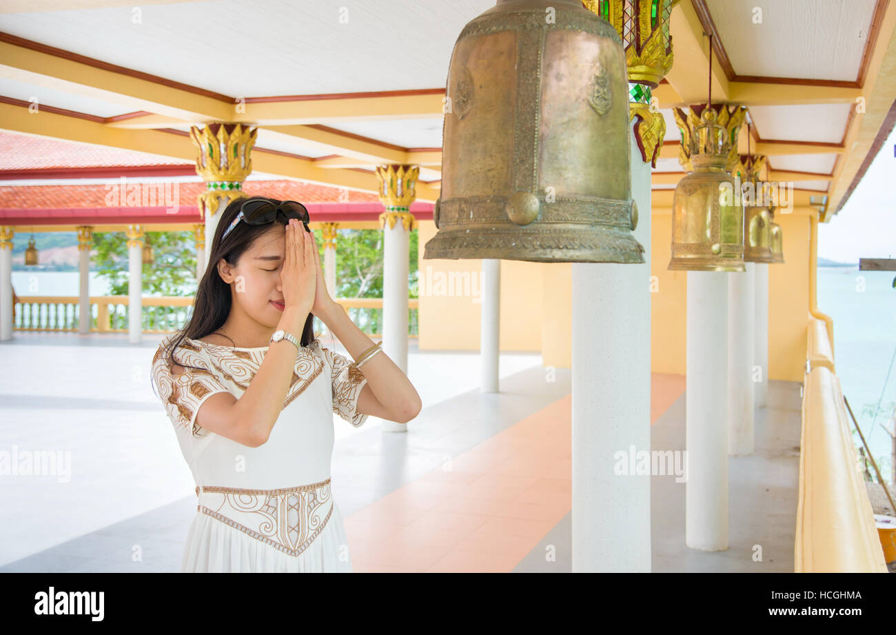 Jeune fille bouddhiste priant à l'intérieur du temple Banque D'Images