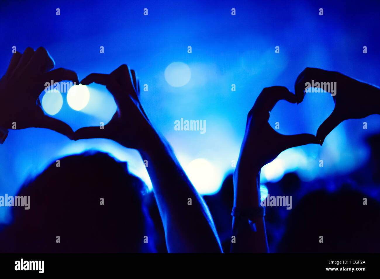 Couple montrant coeurs avec les mains at party Banque D'Images