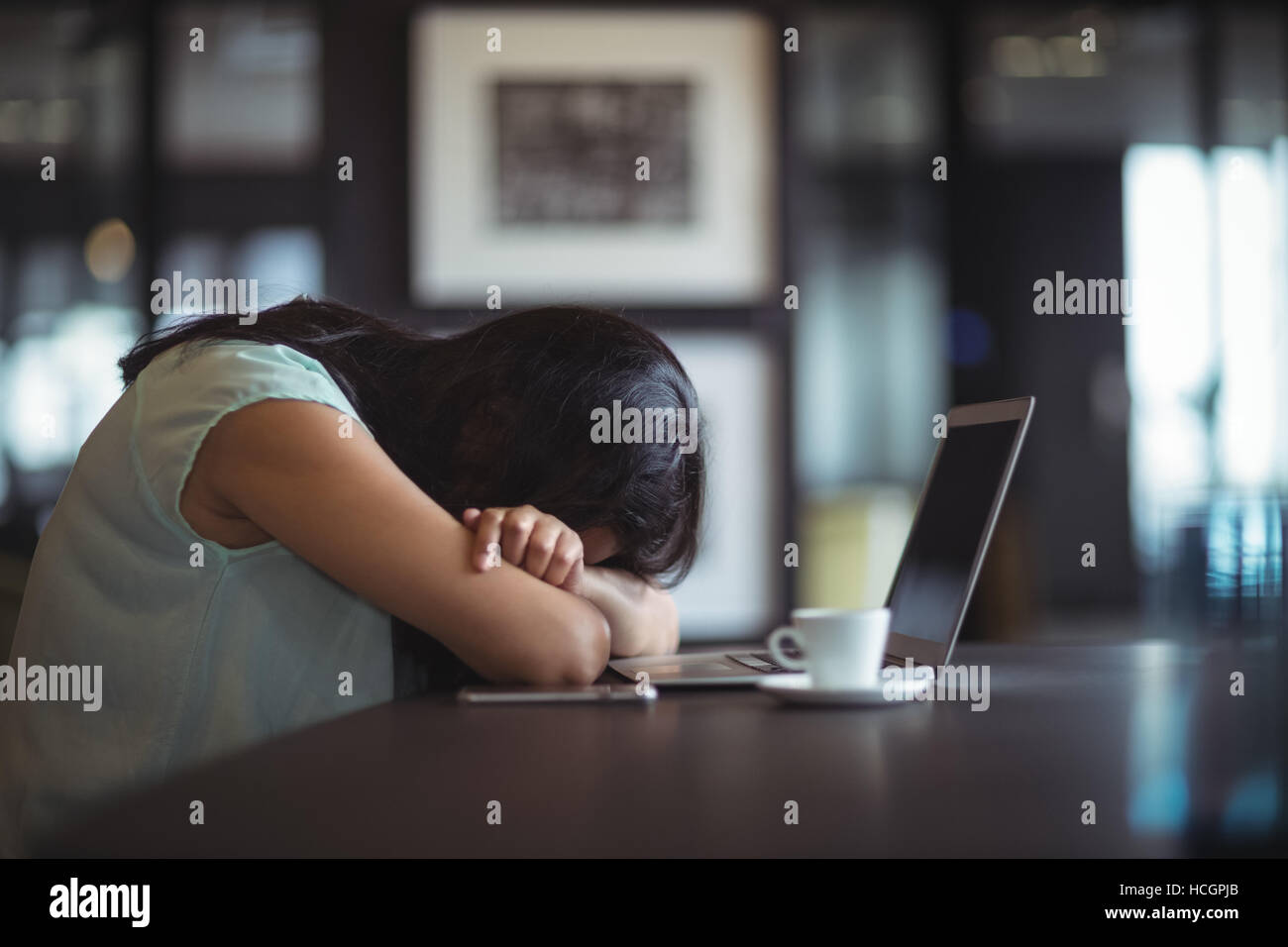 Contrarié businesswoman sitting at her desk Banque D'Images