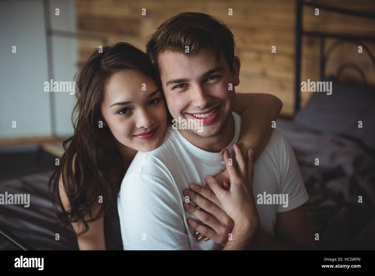 Portrait of smiling couple in bedroom Banque D'Images