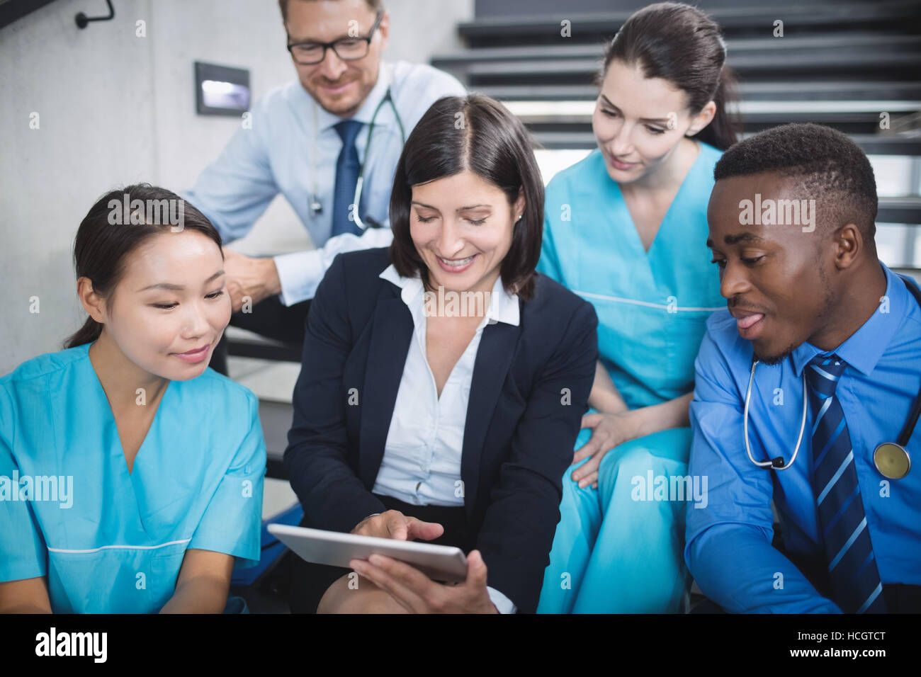 Les médecins et infirmières looking at digital tablet Banque D'Images