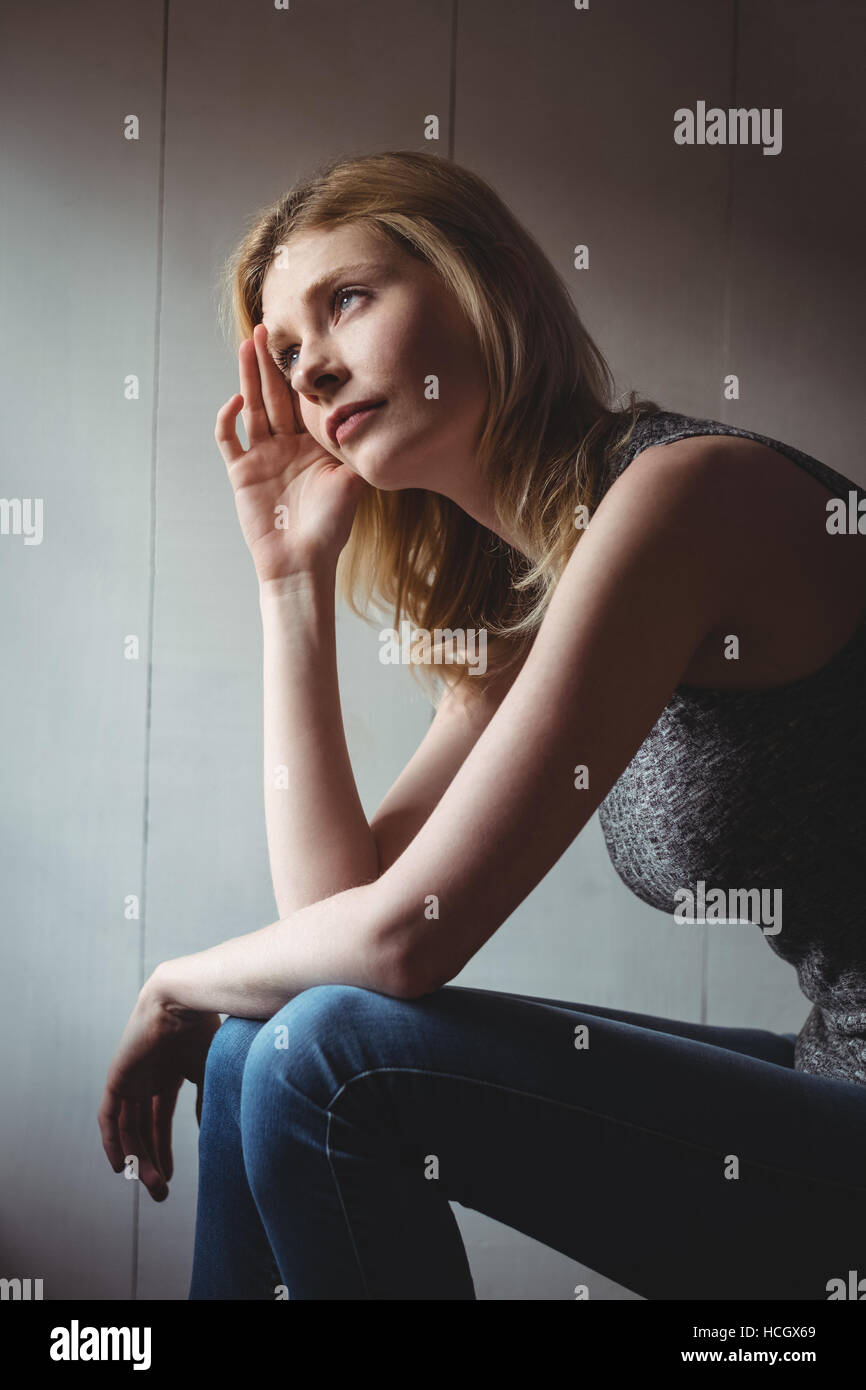 Une femme assise avec la main sur le front Banque D'Images