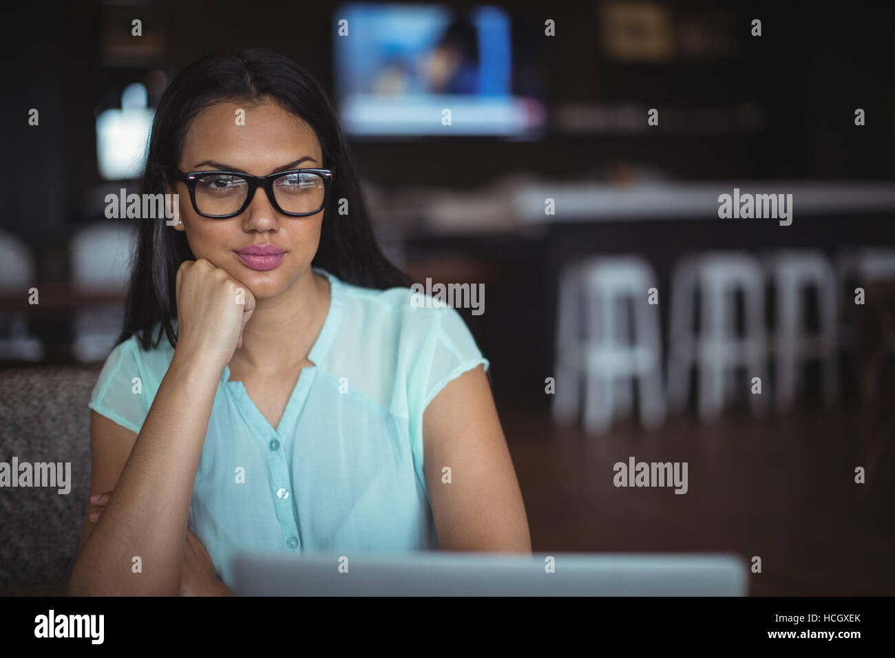 Spectacle woman sitting at her desk Banque D'Images