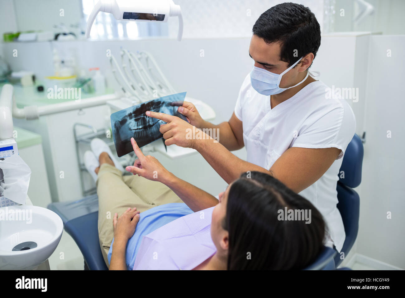 Young male dentist examining X-ray avec la patiente Banque D'Images