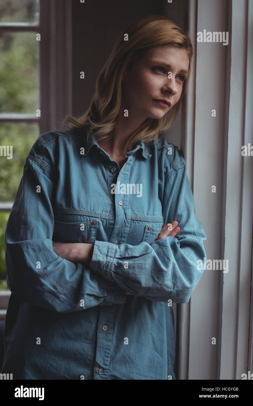 Thoughtful woman leaning on wall Banque D'Images