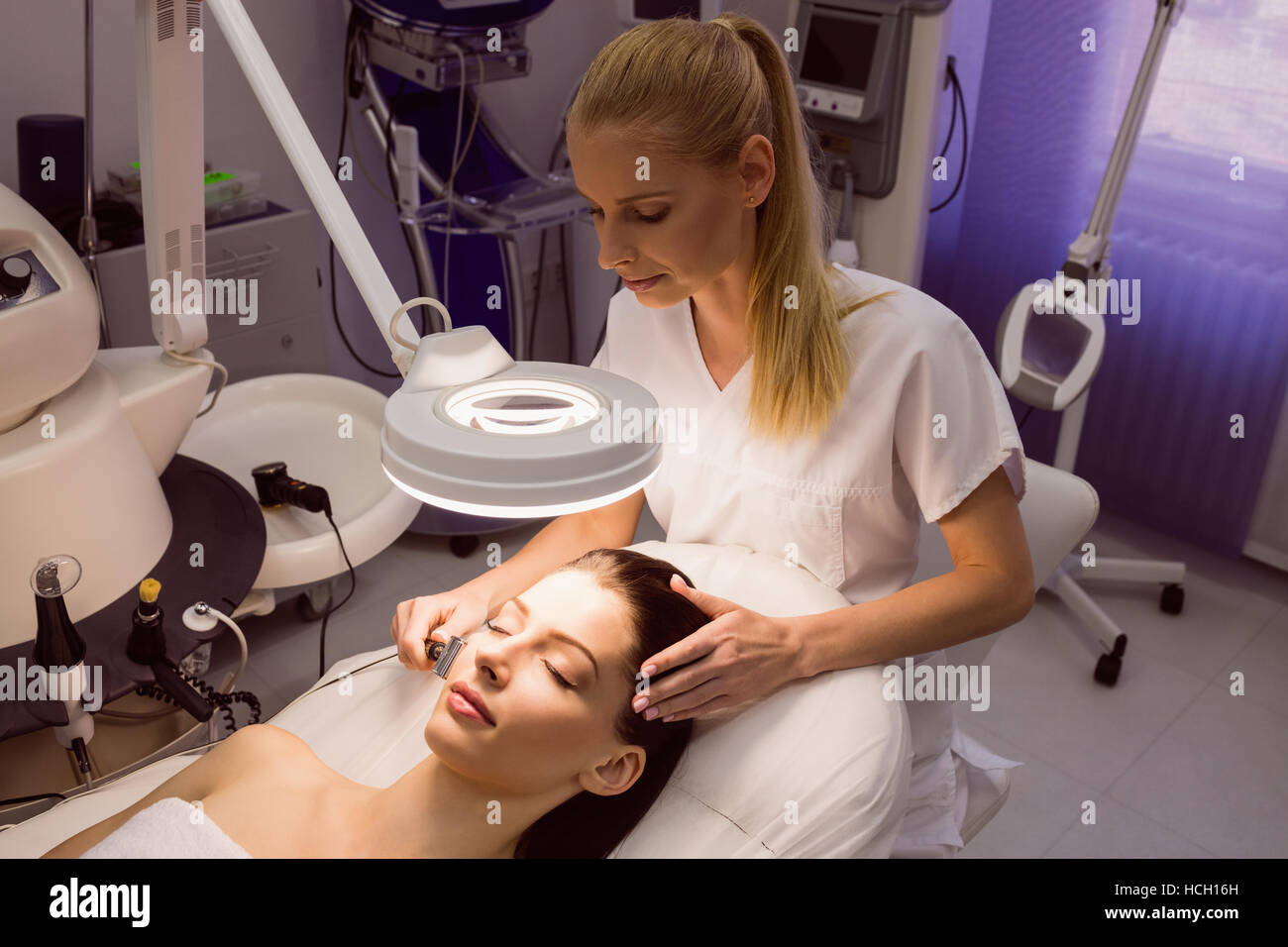 L'exécution de l'enlèvement de cheveux de laser dermatologue sur patient Banque D'Images