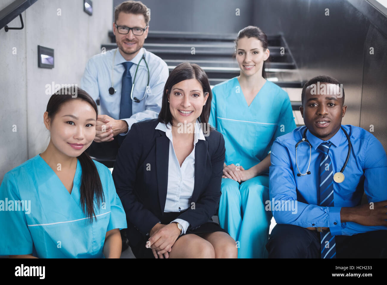 Médecins et infirmières assis on staircase Banque D'Images