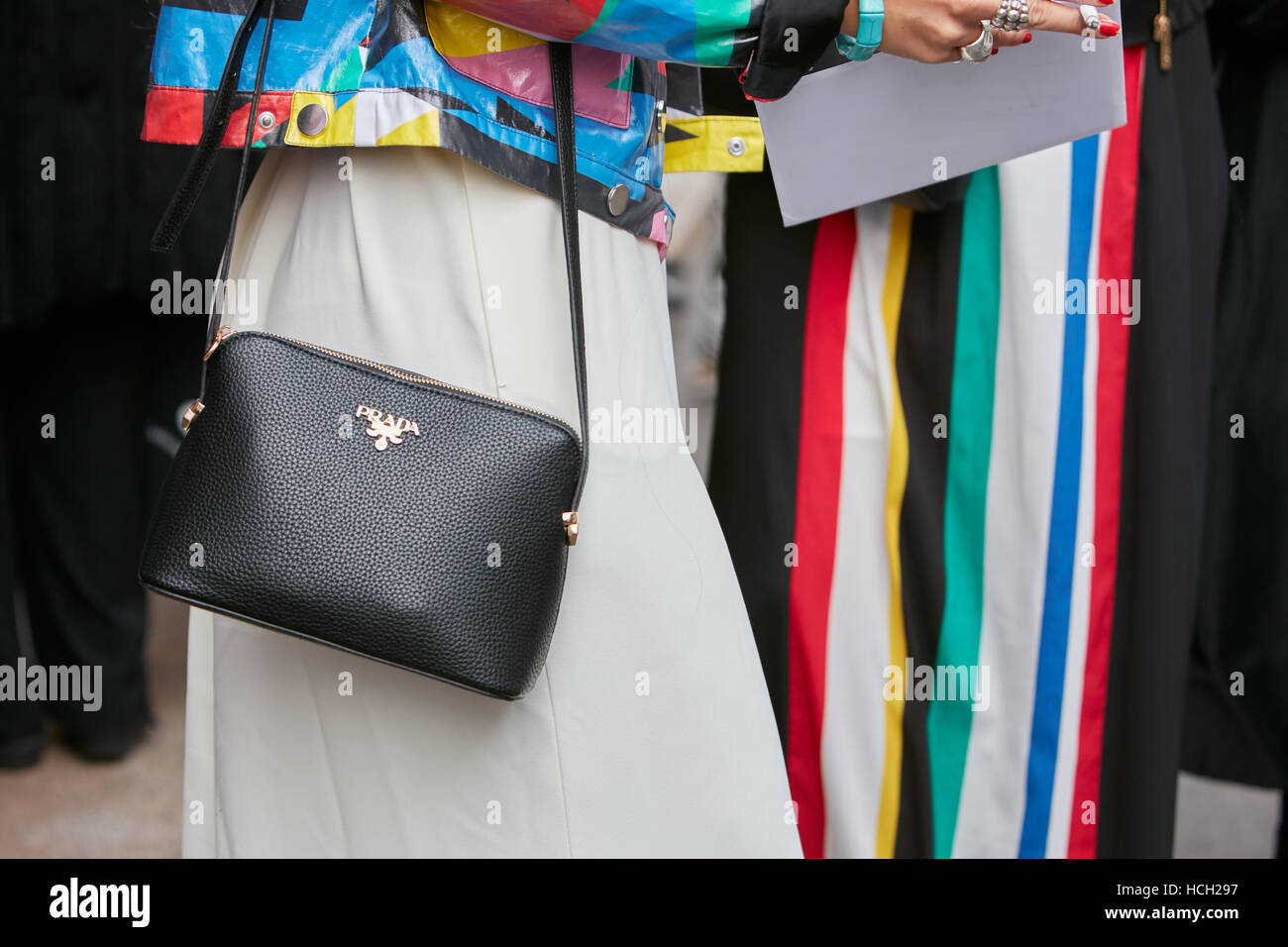 Femme avec sac Prada en cuir noir et des motifs colorés avant Max Mara fashion show, Milan Fashion Week street style, en 2016. Banque D'Images