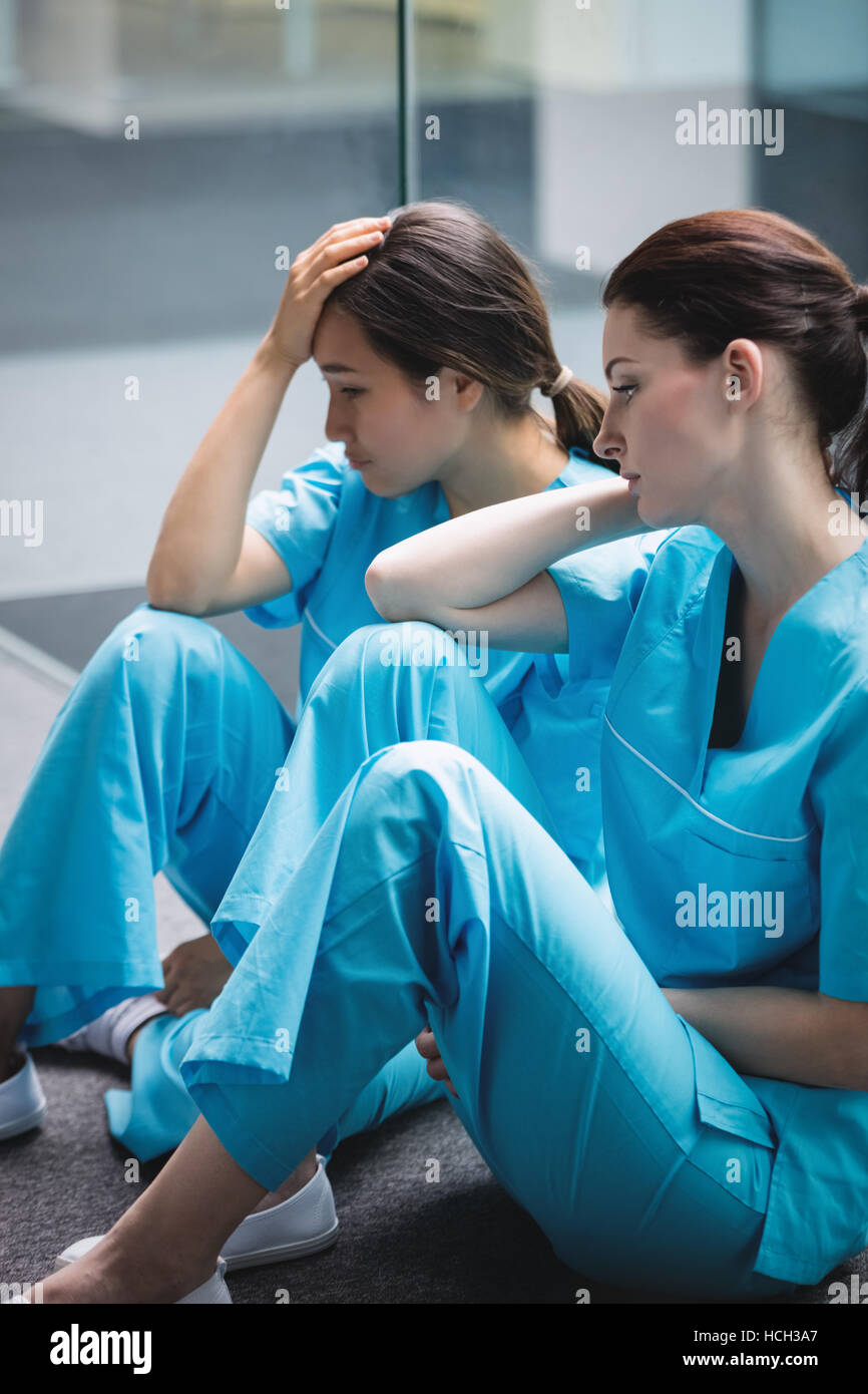Les infirmières triste assis sur couloir Banque D'Images