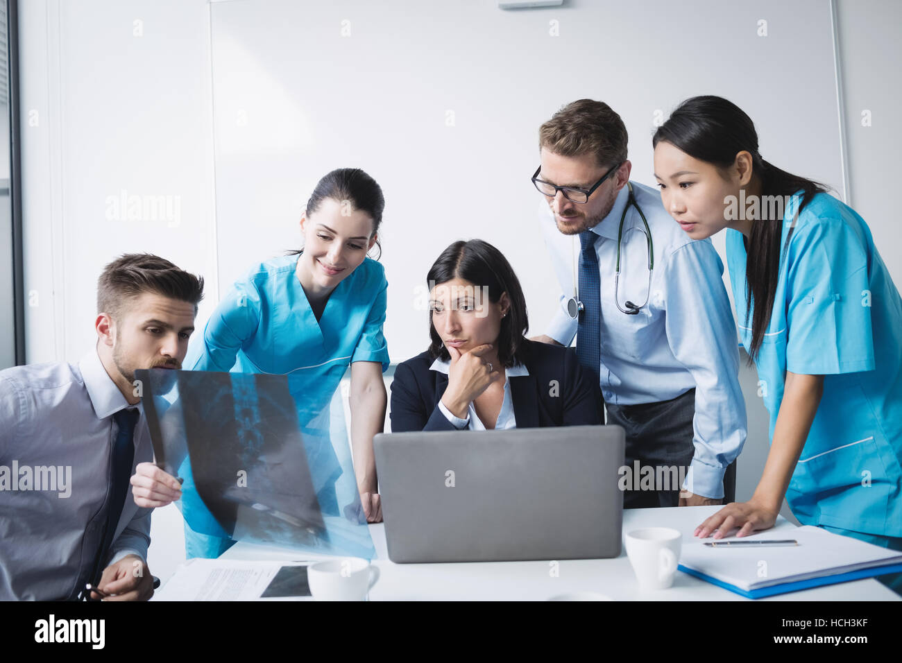 L'équipe médicale de l'examen d'une x-ray report Banque D'Images