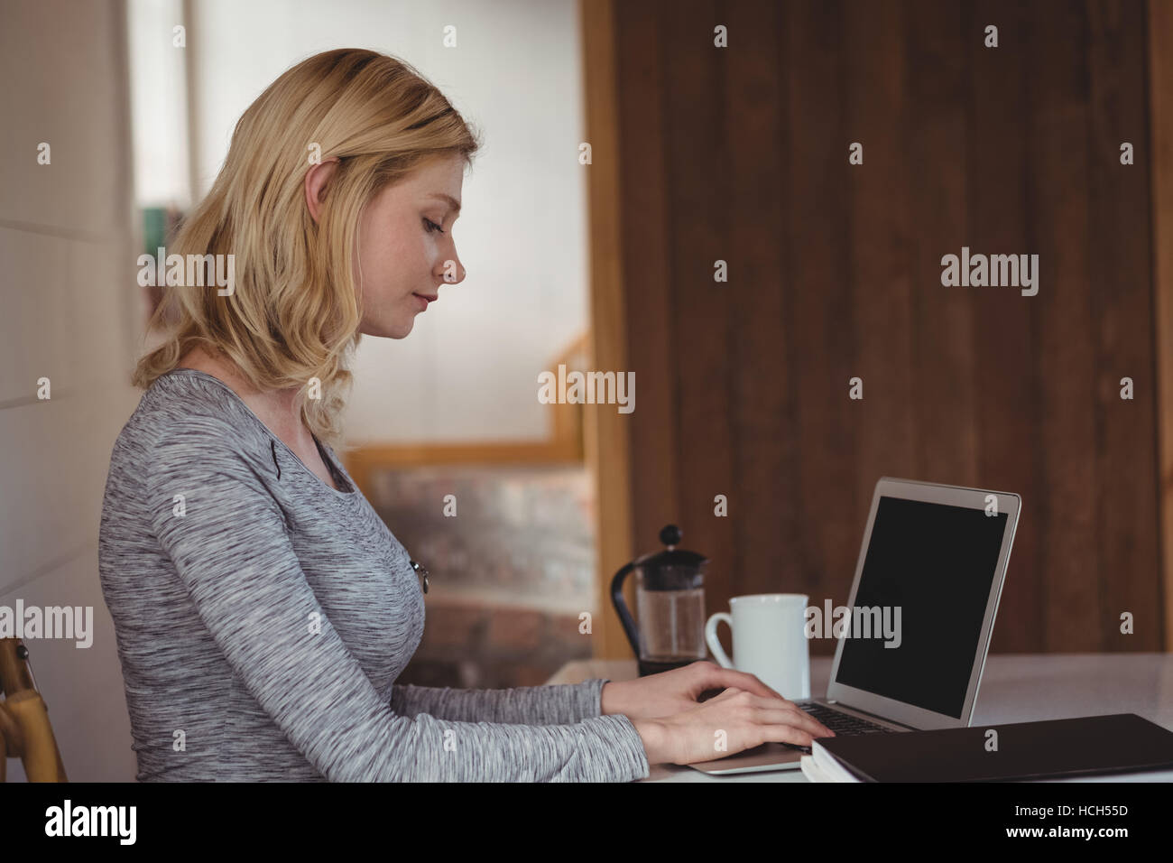 Belle femme assise à table et using laptop Banque D'Images