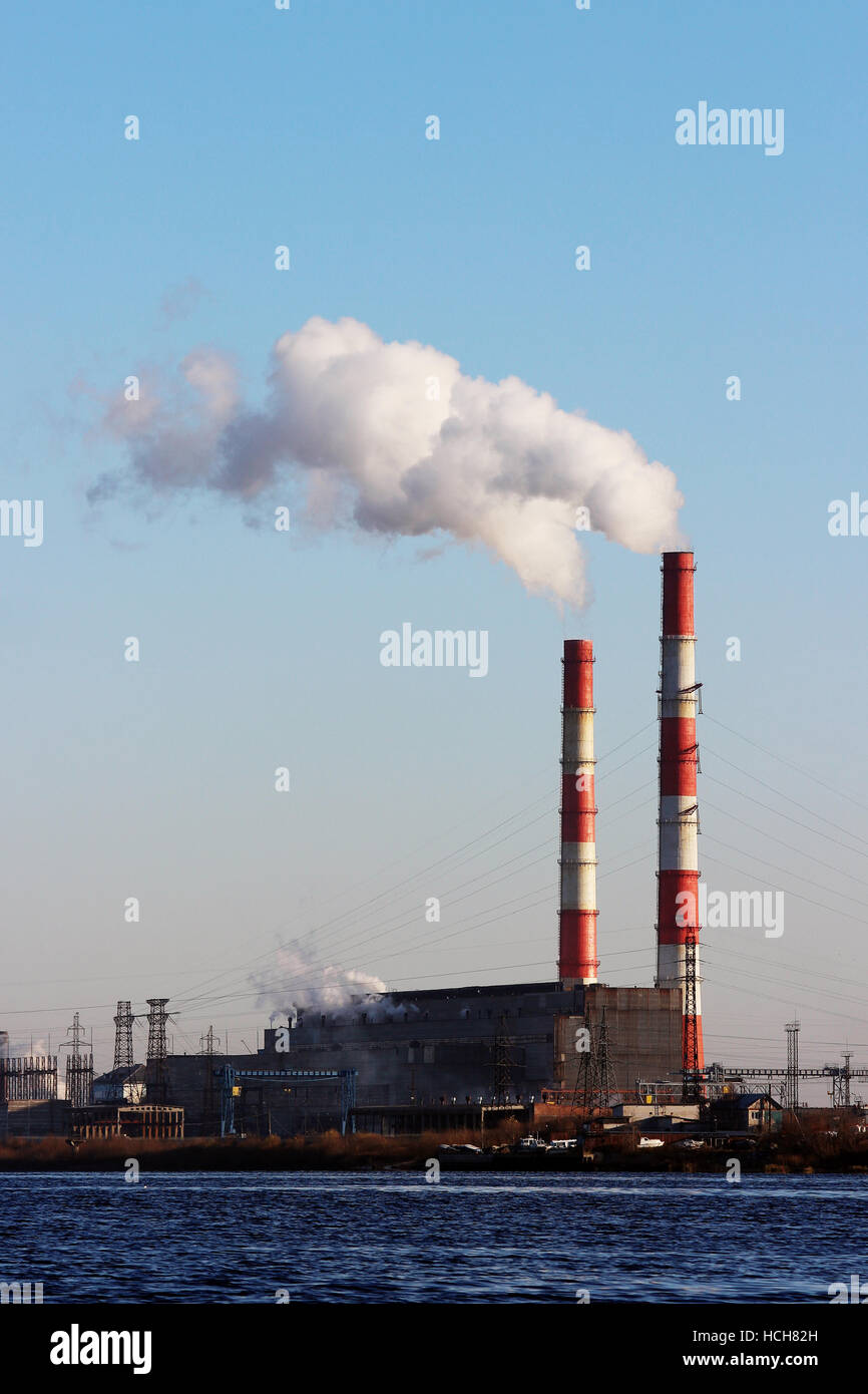 Les tuyaux de cheminée rouge et blanc à côté de la rivière Dvina Septentrionale. Banque D'Images