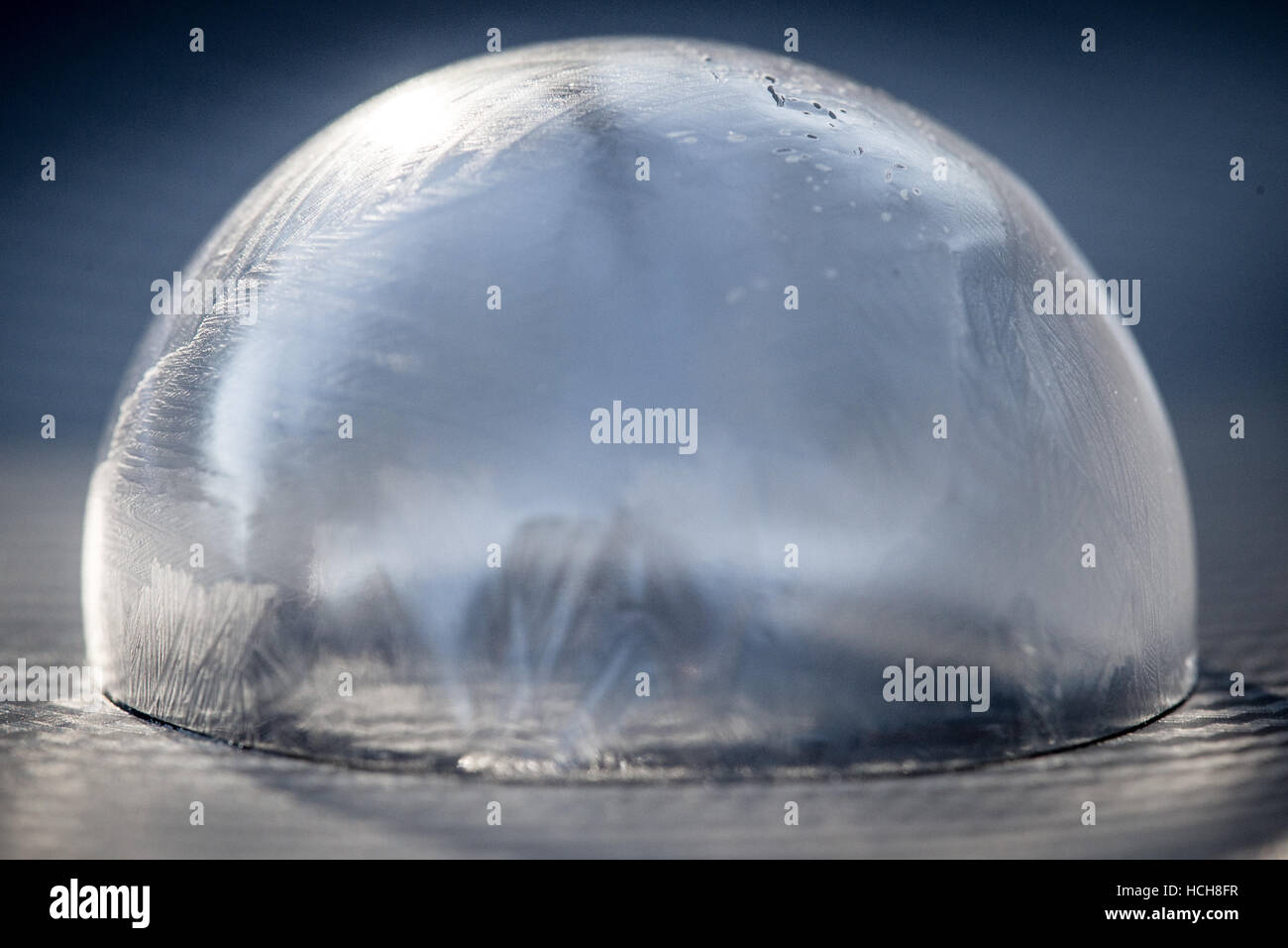 Icy, congelé, bulle de savon sur la surface à motifs gris avec fond bleu Banque D'Images