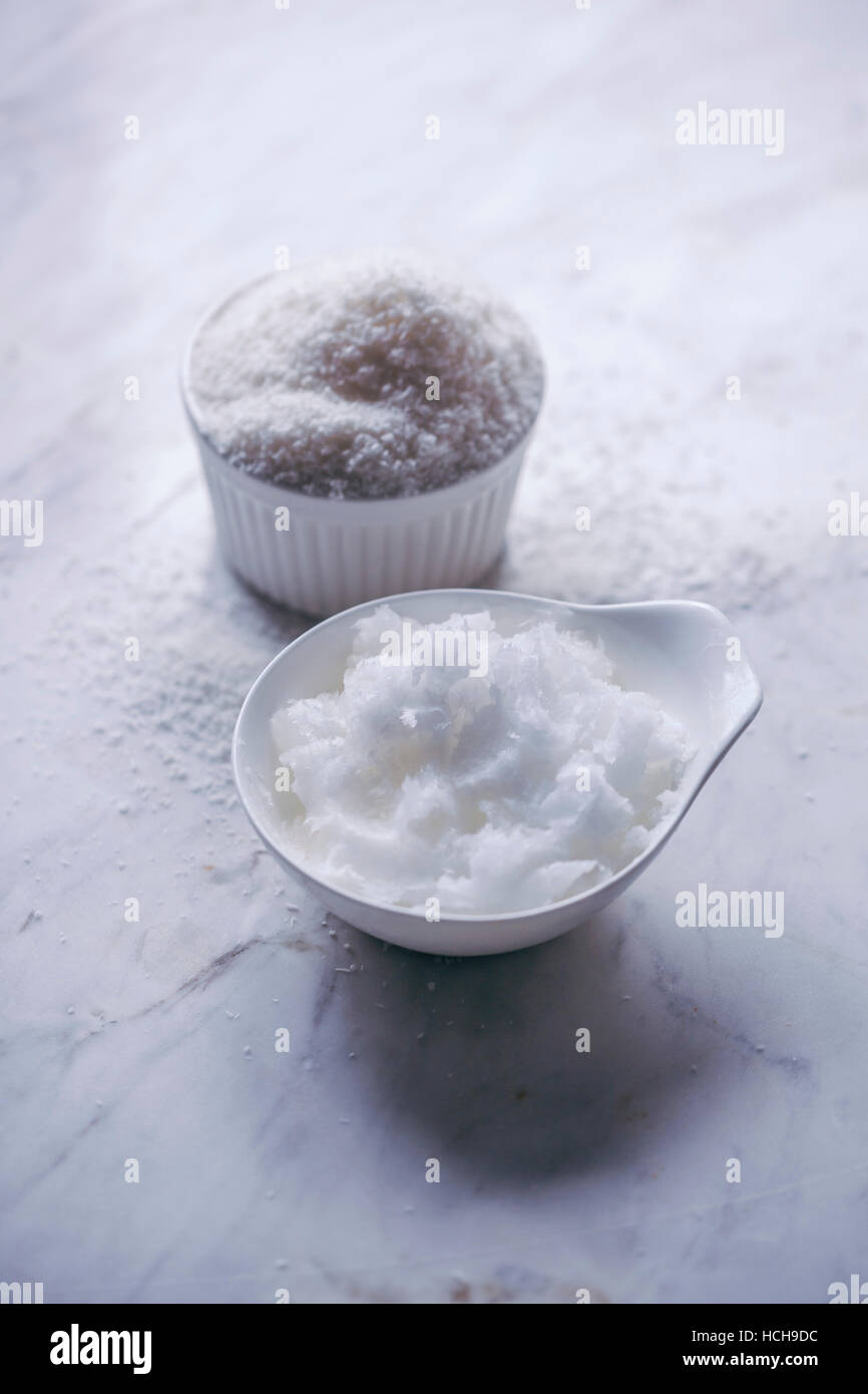 Noix de coco desséchée et l'huile de coco sur table en marbre blanc Banque D'Images