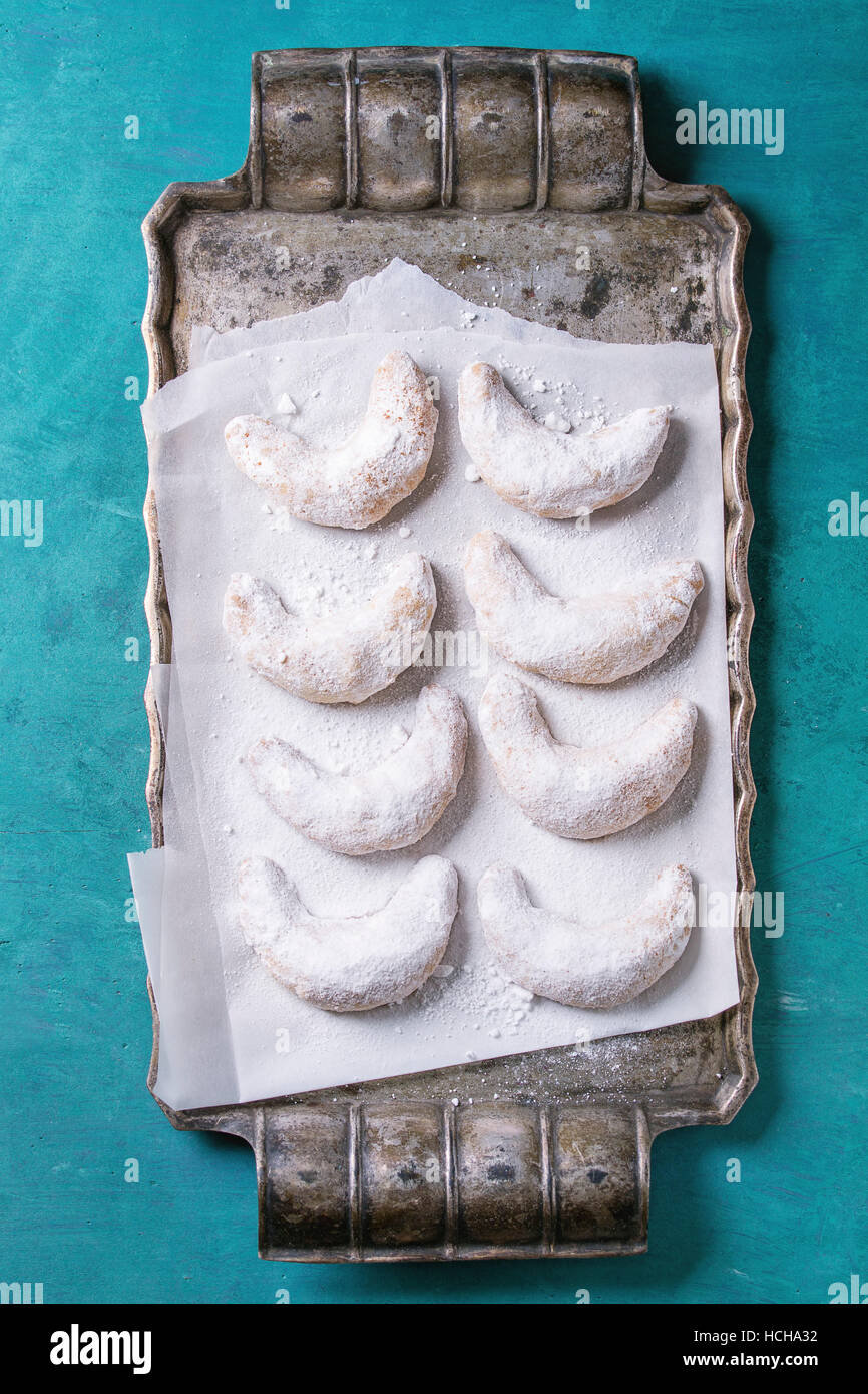 Des cookies noix de Noël avec du sucre en poudre sur crescent vintage metal plateau avec du papier sulfurisé comme sapin sur turquoise texture boisée backgroun Banque D'Images