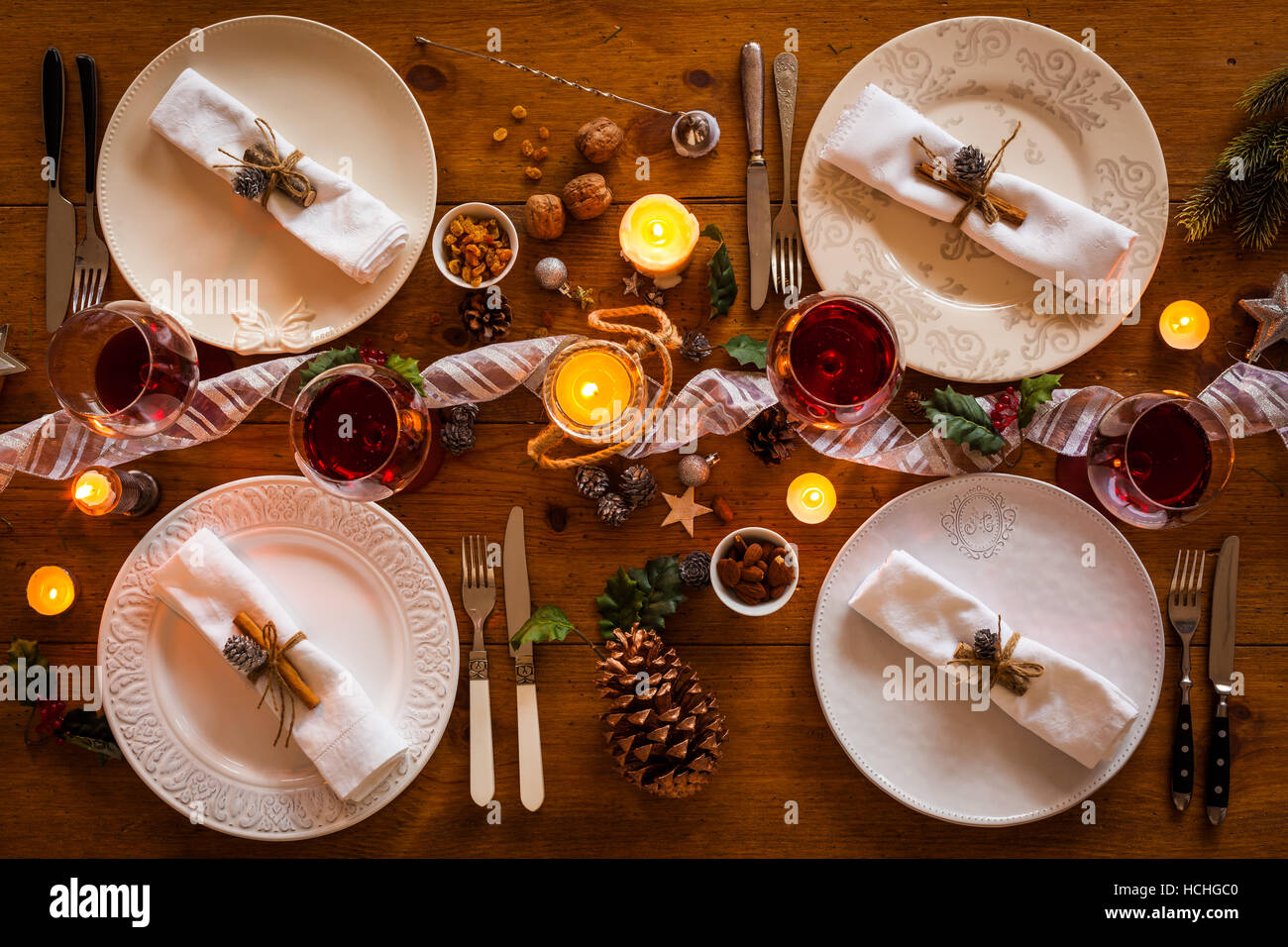 Réglage de la table de Noël de la famille pour le dîner dans le confortable table rustique avec des bougies et des décorations. Vue d'en haut. Banque D'Images