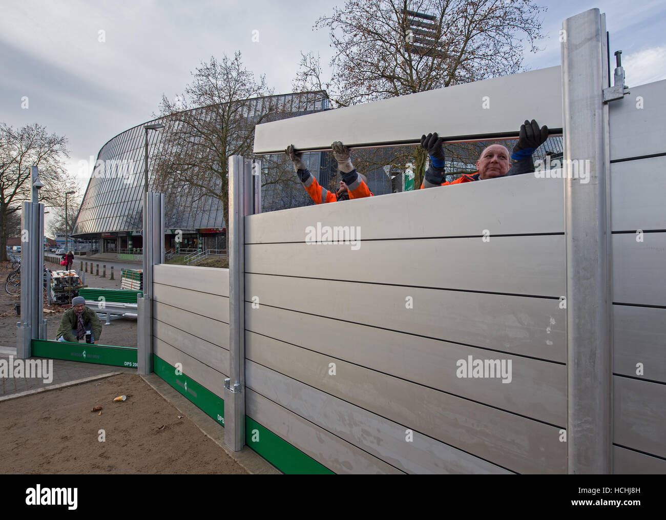 Brême, Allemagne. Le 08 mai 2016. Les ouvriers du montage de la nouvelle barrière de protection contre les inondations mobile lors d'une manifestation devant le stade Weser à Brême, Allemagne, 08 décembre 2016. Le mur est conçu pour compléter une deuxième, mur permanent autour du stade de foot en cas de crues éclair. Photo : Ingo Wagner/dpa/Alamy Live News Banque D'Images