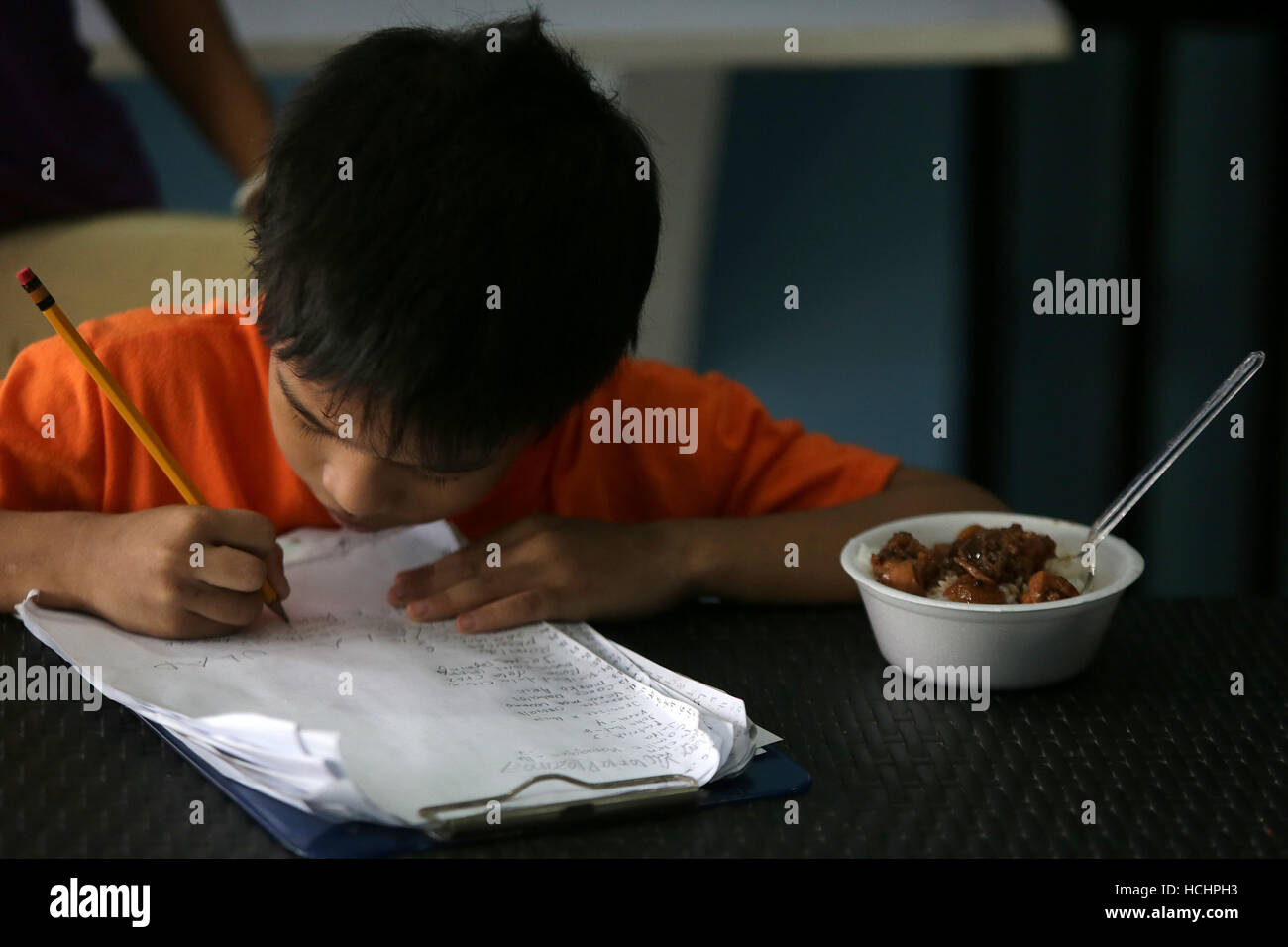 Quezon City, Philippines. 8e Dec 2016. Un garçon enregistre son nom pour un repas gratuit au 'Duterte's Kitchen' dans la ville de Quezon, Philippines, le 8 décembre 2016. La cuisine de 'Duterte', un centre d'alimentation nommé d'après le Président philippin Rodrigo Duterte, offre des repas gratuits aux sans-abri. Le gouvernement des Philippines visant à réduire les taux de pauvreté à entre 13 et 15 pour cent d'ici 2022. © Rouelle Umali/Xinhua/Alamy Live News Banque D'Images