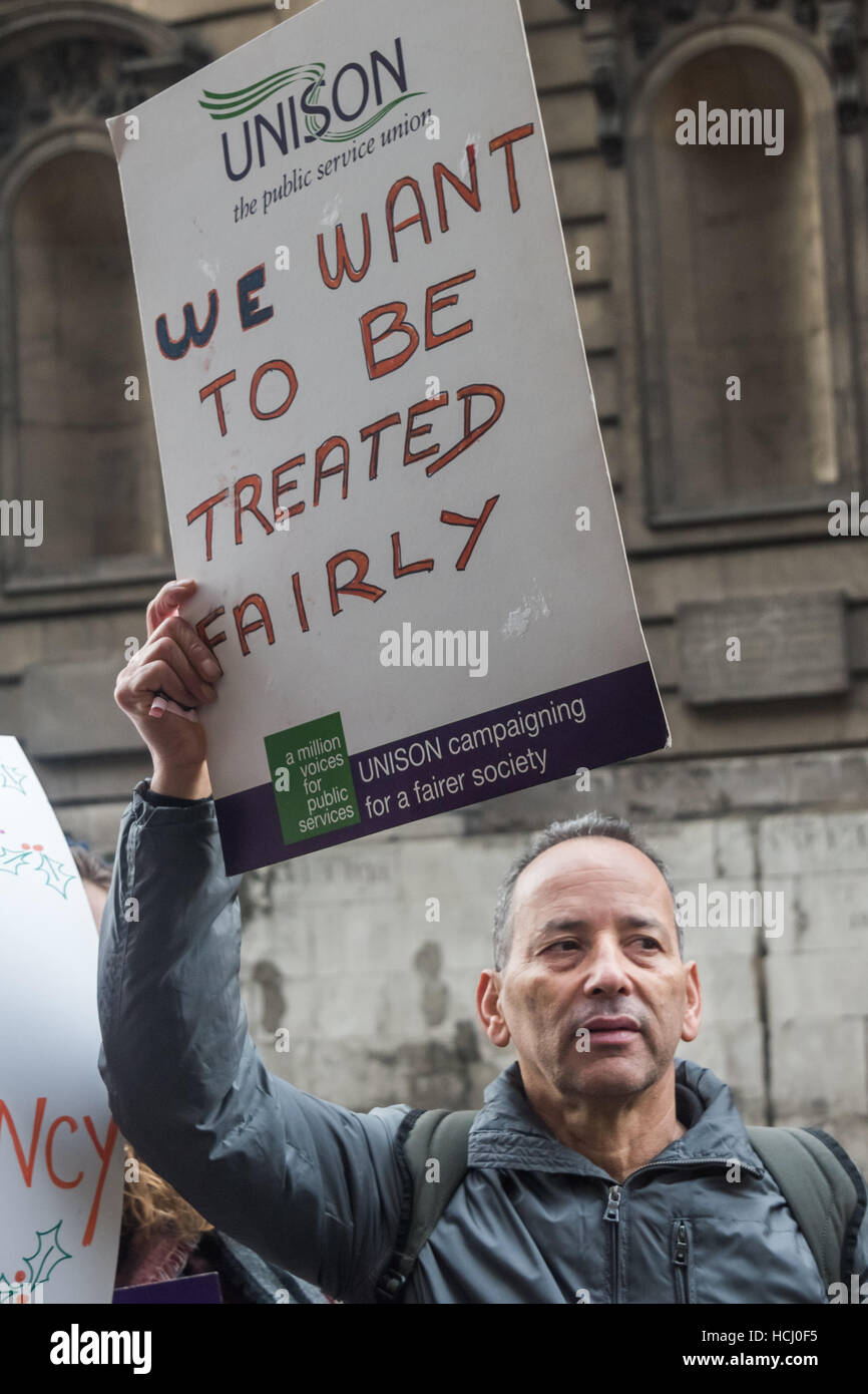 Londres, Royaume-Uni. 9 décembre 2016. Un homme nous tend un unisson poster "Nous voulons être traités équitablement' à la protestation de l'extérieur nettoyeurs King's College sur le brin sur la poursuite de leur différend avec l'entreprise de nettoyage, les charges de personnel plus sers avec persévérance et d'autres questions. Crédit : Peter Marshall/Alamy Live News Banque D'Images