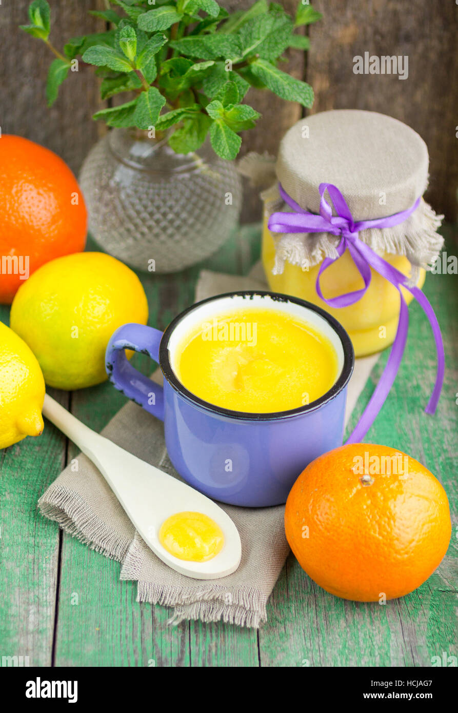 Crème de citron et de citrons frais, les oranges et la menthe sur la vieille table en bois. Kurd Banque D'Images