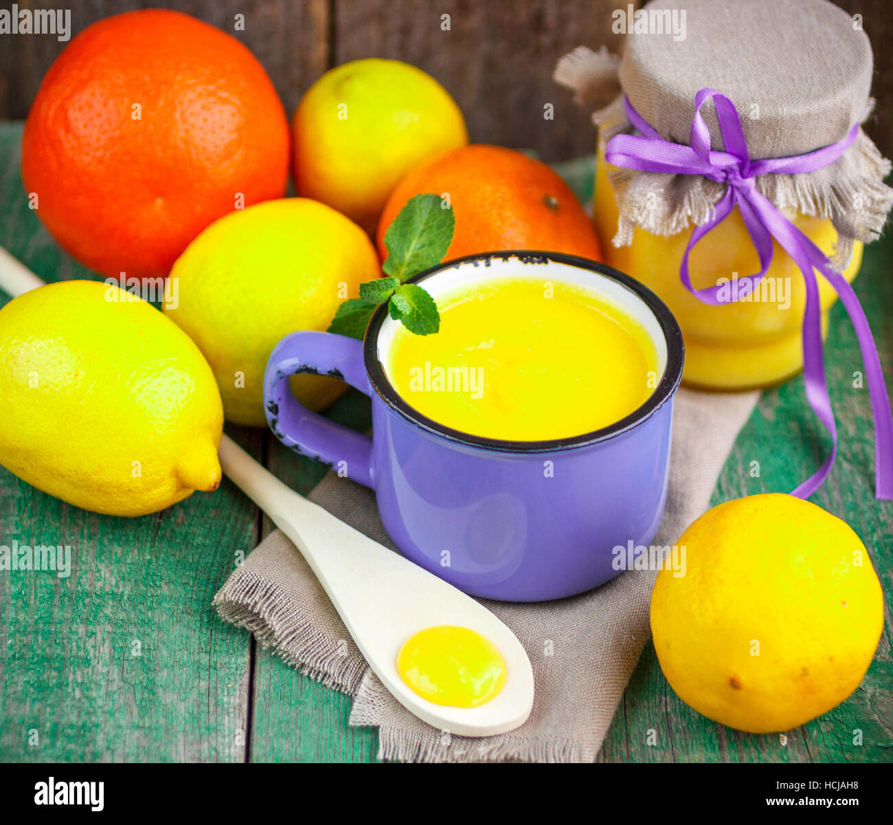 Crème de citron et de citrons frais, les oranges et la menthe sur la vieille table en bois. Kurd Banque D'Images