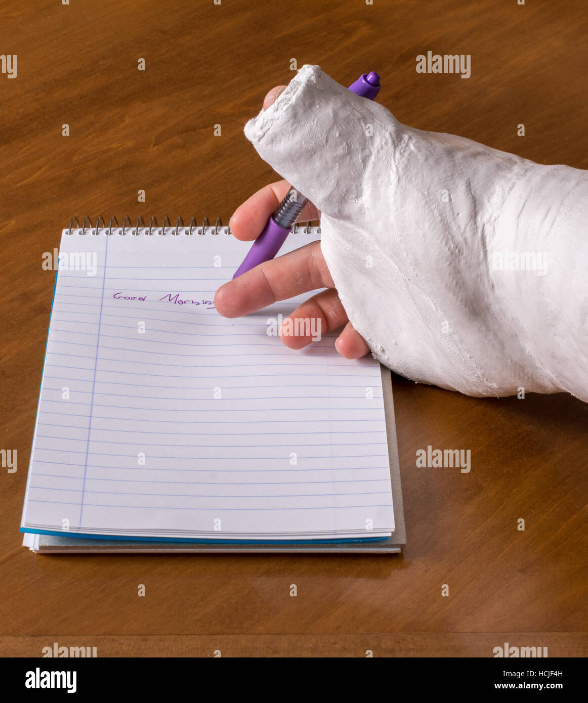 Toute personne portant un bras jeté après avoir cassé le poignet d'essayer d'écrire une note sur un morceau de papier Banque D'Images