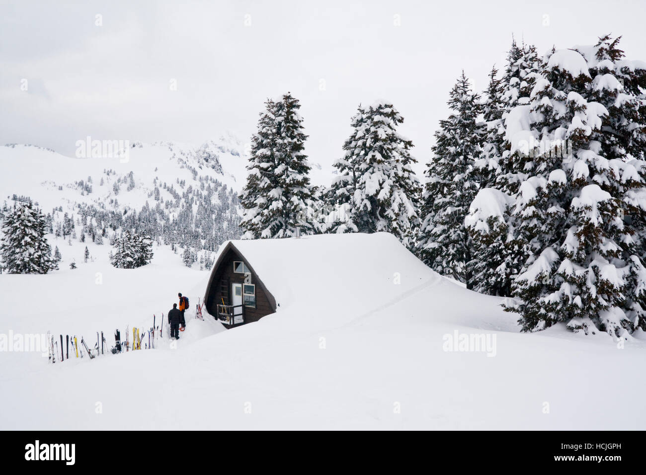 Les skieurs se tiennent à l'extérieur l'Elfin Lakes Hut, un grand abri dans le parc provincial Garibaldi, British Columbia, Canada. Banque D'Images