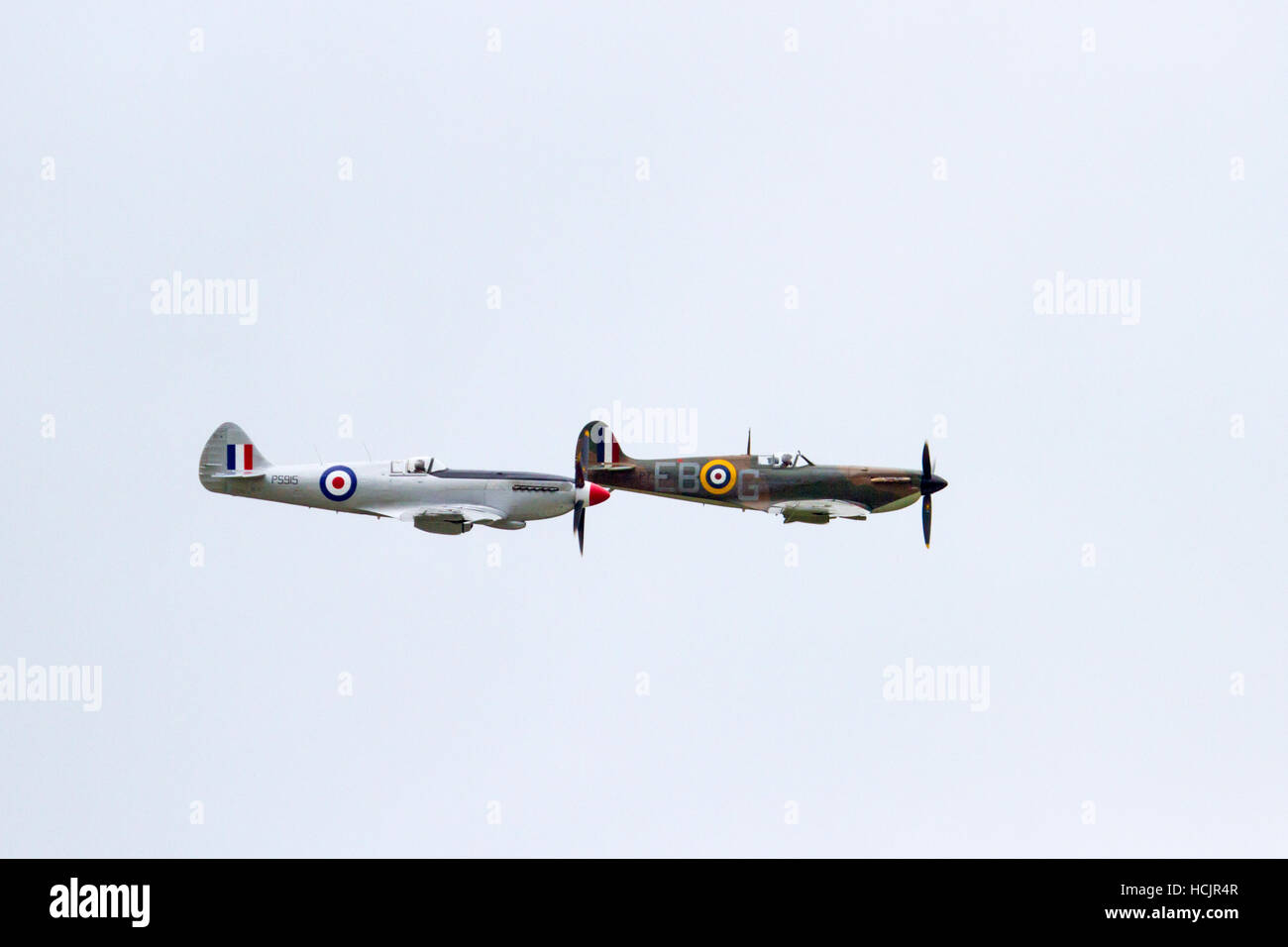Deux versions de l'avion Spitfire flying à côté de l'autre à Dunsfold Airshow, Surrey England Uk Banque D'Images